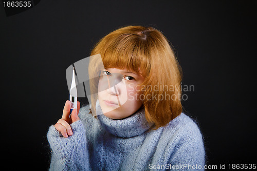Image of sick sad girl with a thermometer