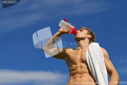 Image of Young athlete drinking water