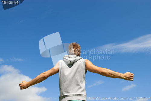 Image of Guy in sports clothing on blue sky background