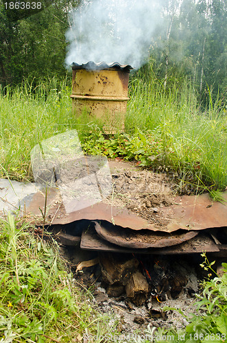 Image of Smoke rises old barrel smokehouse firewood burn 