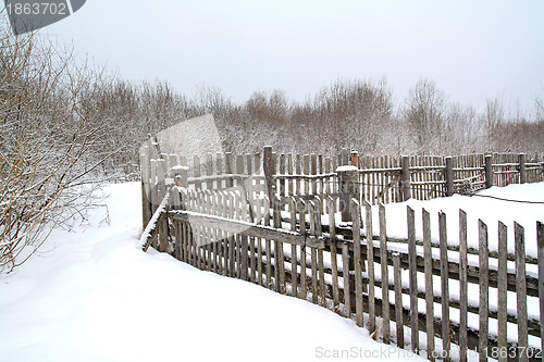 Image of old wooden fence on winter snow