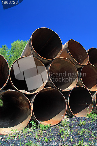 Image of old gas pipes amongst green herb