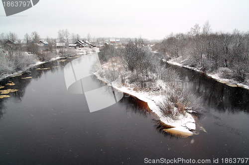 Image of snow village on coast river 