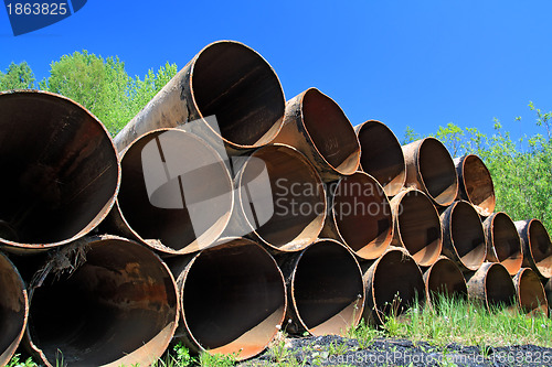 Image of old gas pipes amongst green herb