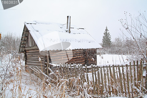 Image of old rural wooden house amongst snow