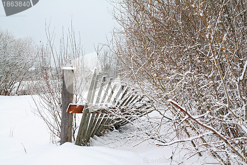 Image of old wooden fence amongst white snow