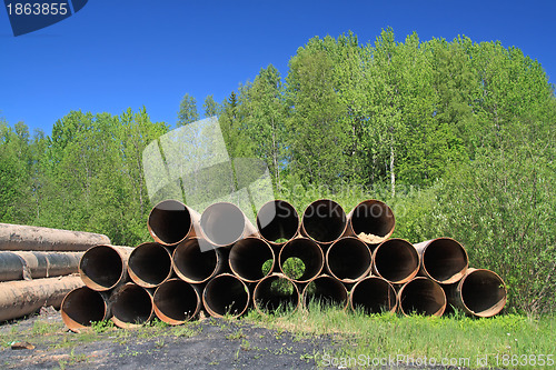 Image of old gas pipes amongst green herb