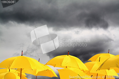 Image of yellow umbrellas on cloudy background