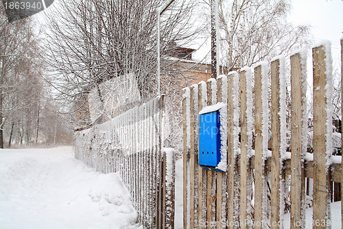 Image of blue mailbox on wooden fence