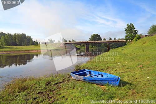 Image of wooden boat on river coast near villages