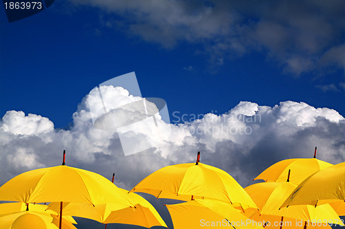 Image of yellow umbrellas on cloudy background