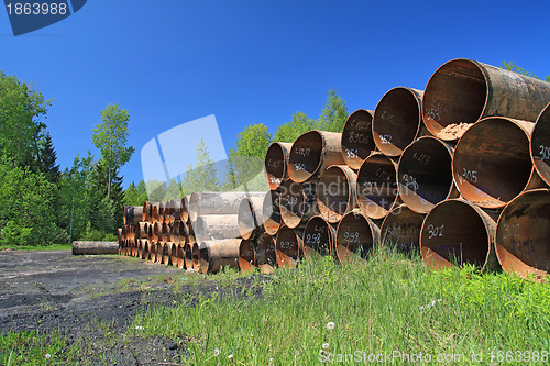 Image of old gas pipes amongst green herb