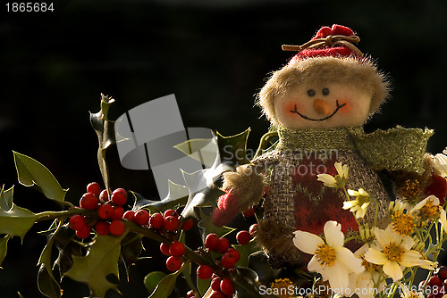 Image of Christmas, snowman on a branch of holly