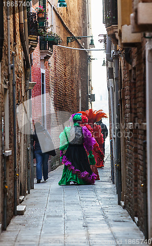 Image of Venetian Costumes Walking on a Narrow Street in Venice