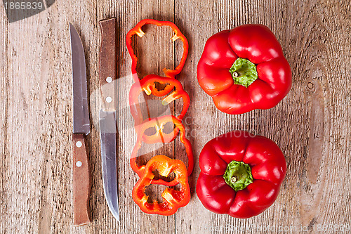 Image of red bell peppers and old knifes 