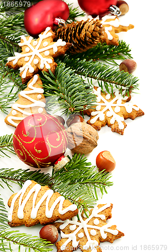 Image of Christmas toys, fir branches and ginger biscuits.