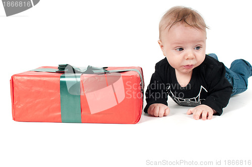 Image of Beautiful baby boy lying near christmas present