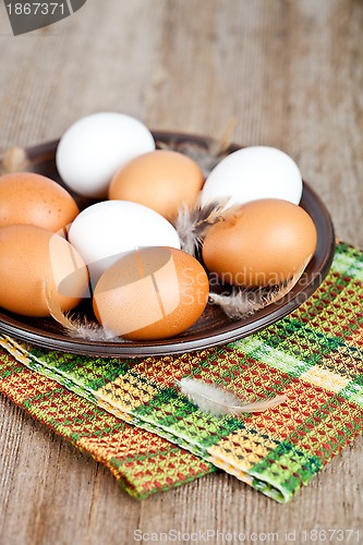 Image of eggs in a plate, towel and feathers