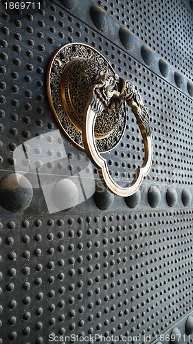 Image of Ancient iron door with a copper doorknob