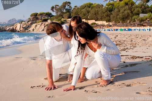 Image of happy young family with daughter on beach in summer