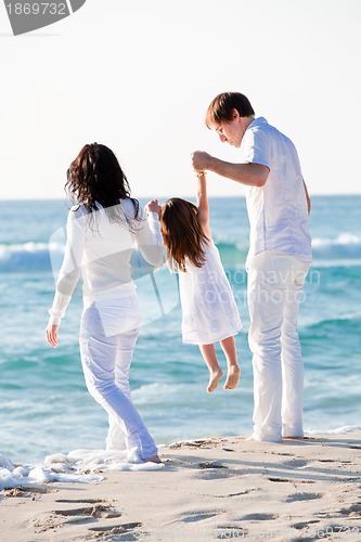 Image of happy young family with daughter on beach in summer