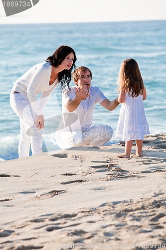 Image of happy young family with daughter on beach in summer
