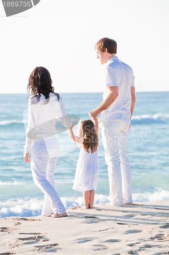 Image of happy young family with daughter on beach in summer