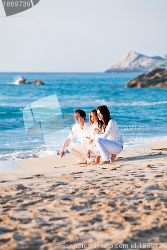 Image of happy young family with daughter on beach in summer