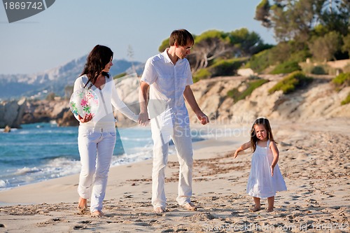 Image of happy young family with daughter on beach in summer