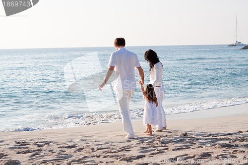 Image of happy young family with daughter on beach in summer
