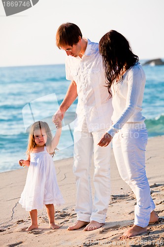 Image of happy young family with daughter on beach in summer