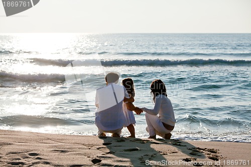 Image of happy young family with daughter on beach in summer