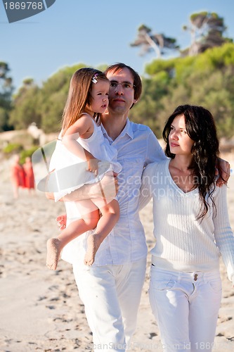 Image of happy young family with daughter on beach in summer