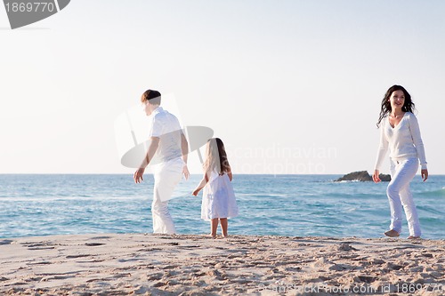 Image of happy young family with daughter on beach in summer