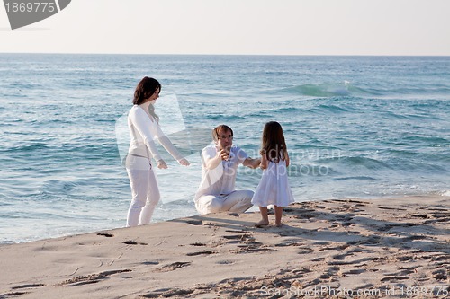 Image of happy young family with daughter on beach in summer