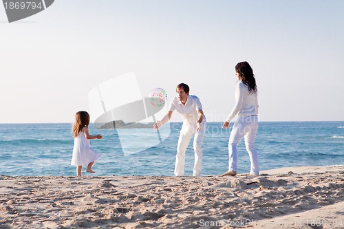 Image of happy young family with daughter on beach in summer