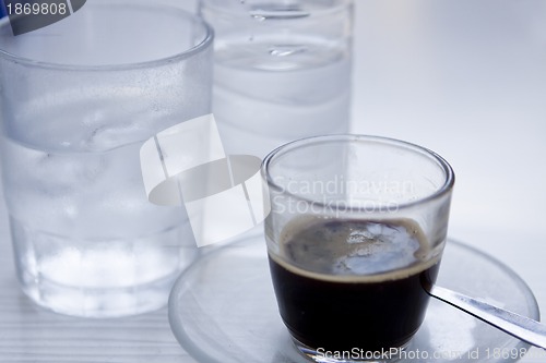 Image of hot aromatic espresso cup and cold water in glass