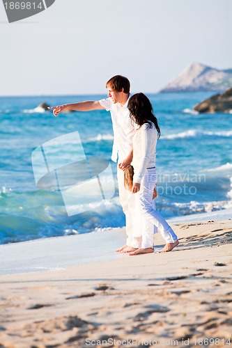Image of happy young family with daughter on beach in summer