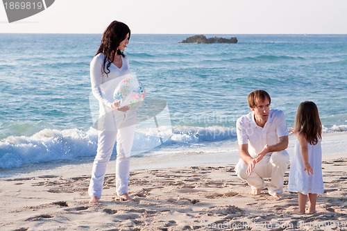 Image of happy young family with daughter on beach in summer