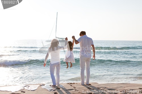 Image of happy young family with daughter on beach in summer