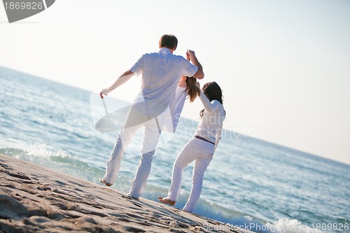 Image of happy young family with daughter on beach in summer