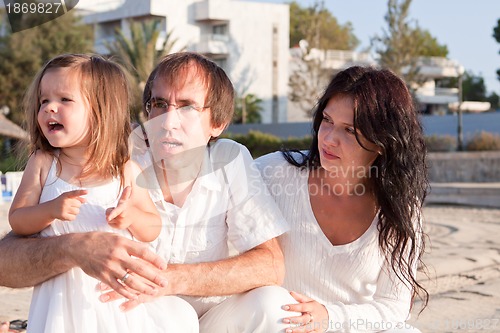 Image of happy young family with daughter on beach in summer