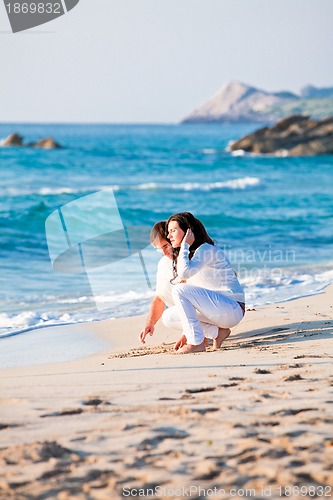 Image of happy young family with daughter on beach in summer