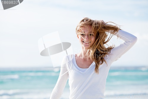 Image of beautiful young woman relaxing at beach in summer 