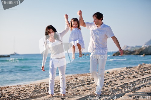 Image of happy young family with daughter on beach in summer