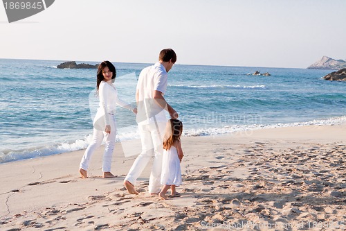 Image of happy young family with daughter on beach in summer
