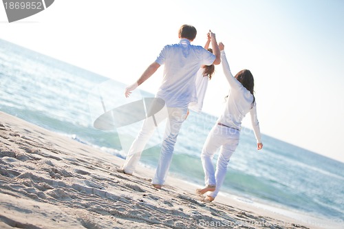 Image of happy young family with daughter on beach in summer