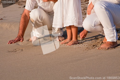 Image of happy young family with daughter on beach in summer