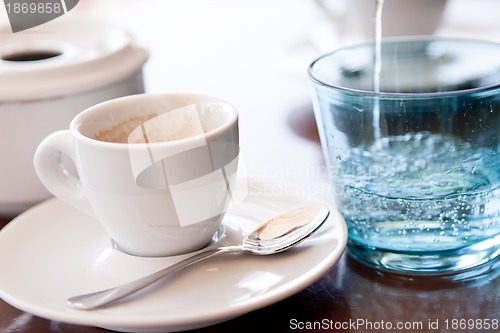 Image of hot aromatic espresso cup and cold water in glass