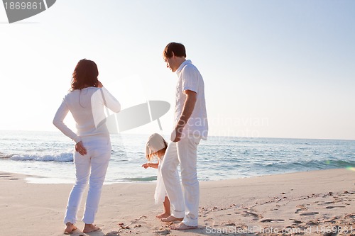Image of happy young family with daughter on beach in summer